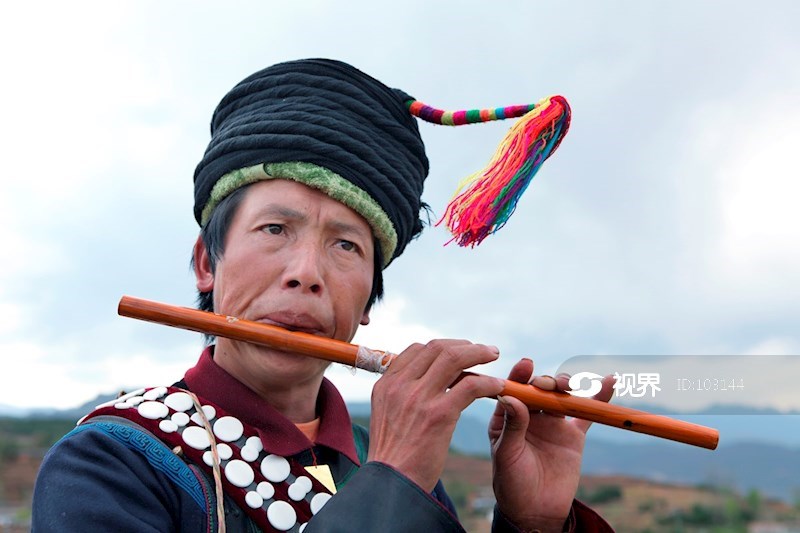 吹笛子的彝族男子