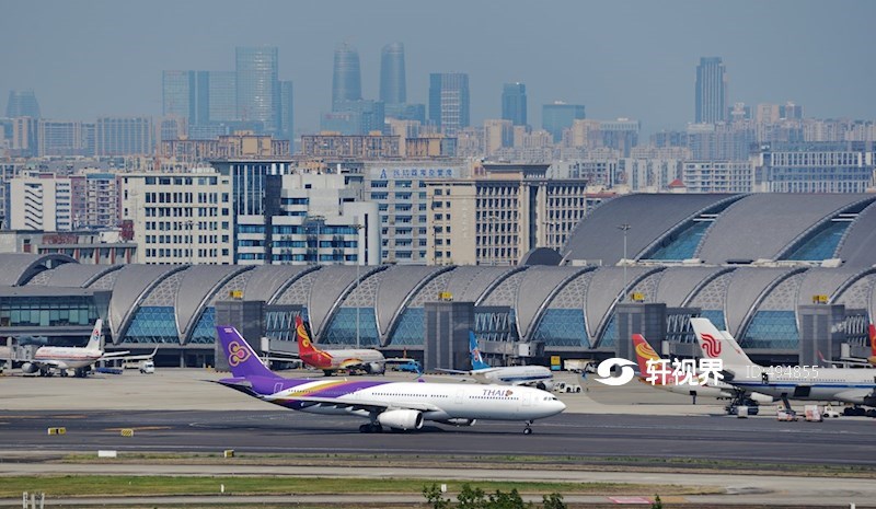 晴天俯瞰四川成都双流国际机场航站楼和远处密集的市区高楼 图片 | 轩视界