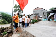 6月29日，泸州市纳溪区棉花坡镇高洞村4社，周明华与母亲、儿子、儿媳妇及孙子一起升旗。这是一个简单的升国旗的仪式，一个73岁的农村妇女带着一家人。年龄最大者93岁，最小的12岁。2012年至今，旗杆已经更换三次，由最初的竹竿到现在的不锈钢旗杆，国旗已经更换了两面，旧的国旗，周明华老人摘取下来后，洗净折叠存放。