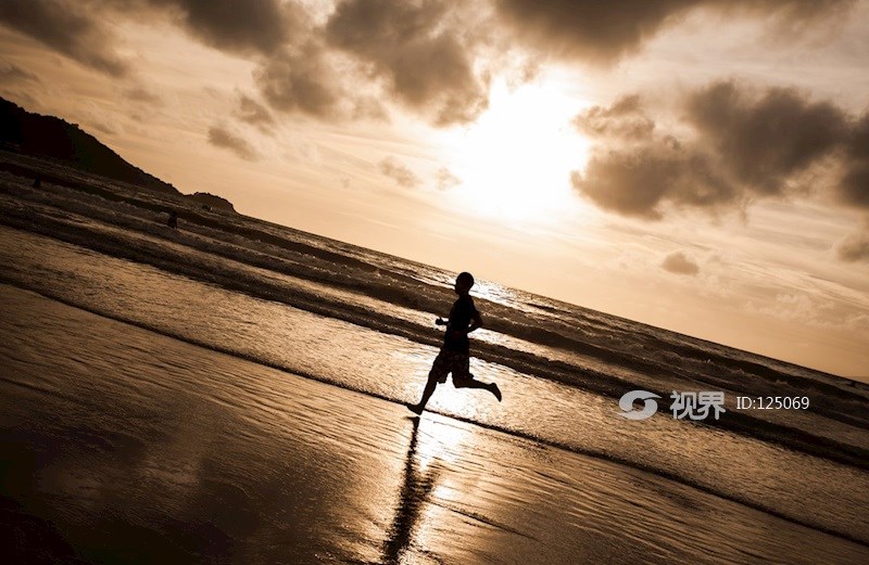傍晚泰国普吉岛巴东海滩锻炼奔跑的人