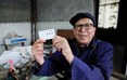 四川省泸州市龙马潭区特兴镇河湾村76岁的独居老人李泽成展示法律援助便民卡。